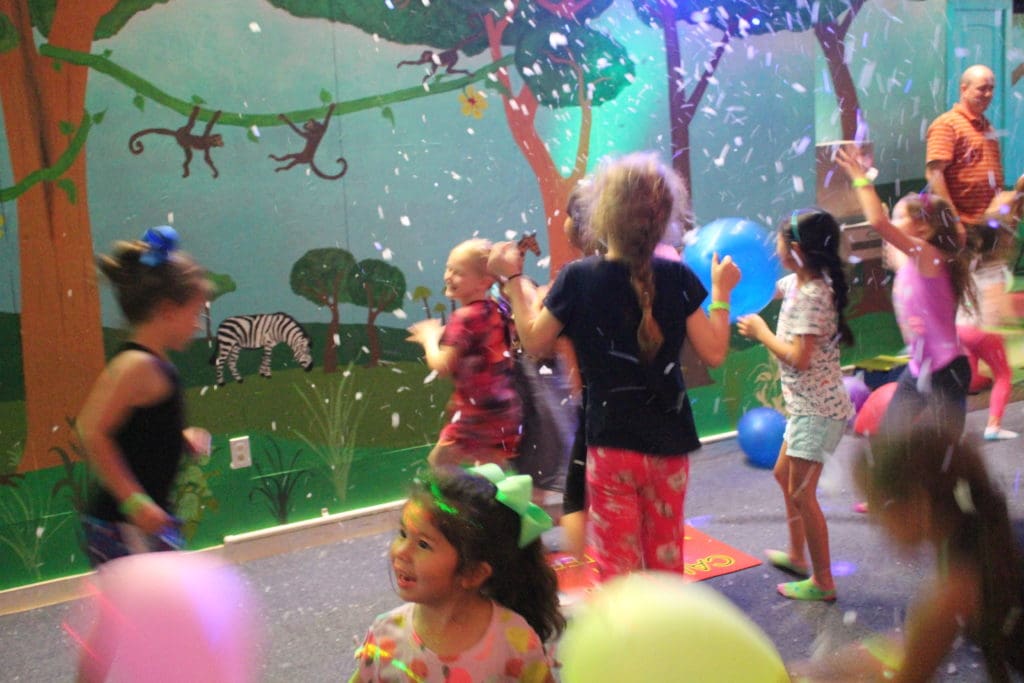Kids jumping and having fun in the Kicky & Tink's jungle-themed party room